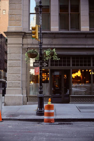 Passage piétonnier près du restaurant et poteau de rue avec pots de fleurs et feux de circulation dans la ville de New York — Photo de stock