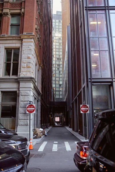 Autos, die in der Nähe geparkt werden, fahren nicht in Straßenschilder zwischen modernen Gebäuden an der Stadtstraße in New York City — Stockfoto