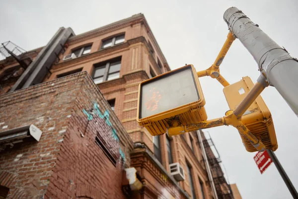 Vue à angle bas du poteau de rue avec feux de circulation près des bâtiments en brique sur la rue à New York — Photo de stock