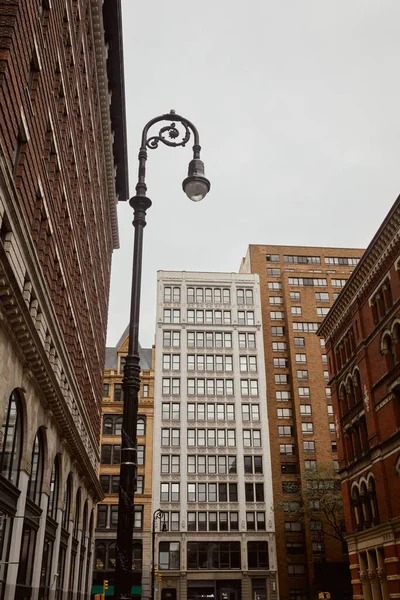 Low angle view of decorated lantern near buildings in downtown of york city, metropolis streetscape — Stock Photo