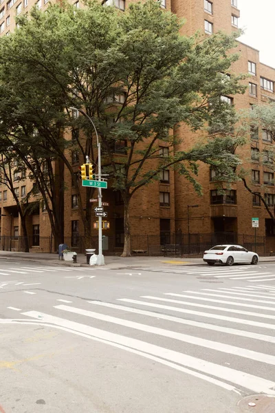 Arbres d'automne et bâtiment en brique près de l'intersection de la circulation avec passage piétonnier dans la ville de New York — Photo de stock