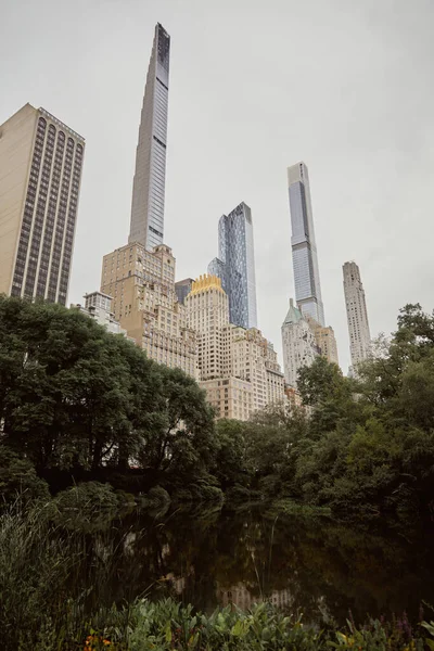 Vista panorámica del parque central contra rascacielos modernos en la ciudad de Nueva York, escena de la metrópoli otoñal - foto de stock