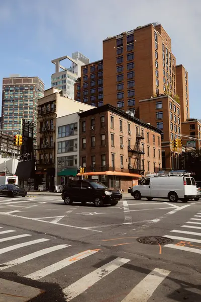 Voitures se déplaçant à l'intersection de la circulation avec passage piétonnier sur l'avenue large dans le centre-ville de New York — Photo de stock