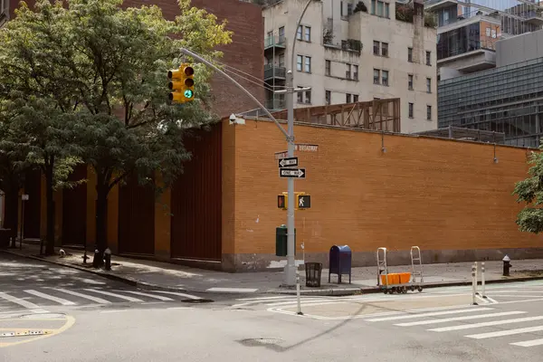 Clôture en brique près du poteau routier avec feu de circulation de carrefour avec passage piétonnier dans la ville de New York — Photo de stock
