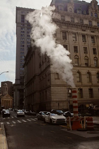 NOVA IORQUE, EUA - NOVEMBRO 26, 2022: Avenida da cidade de Nova Iorque com veículos em movimento na estrada perto de tubulação de vapor, ambiente de metrópole — Fotografia de Stock