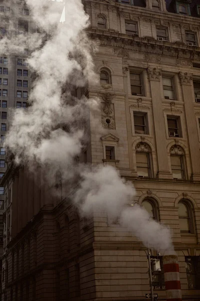 Tubo de vapor y edificio de época en la calle en el centro de la ciudad de Nueva York, atmósfera metrópoli - foto de stock