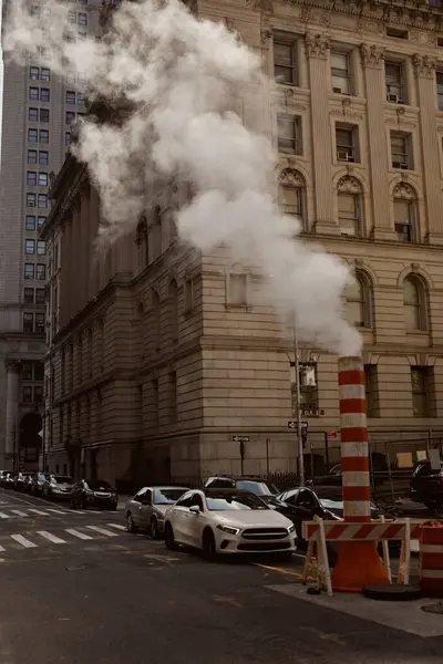 Улица Нью-Йорка с транспортными средствами, движущимися по проезжей части рядом с паровой трубой, городская атмосфера — стоковое фото