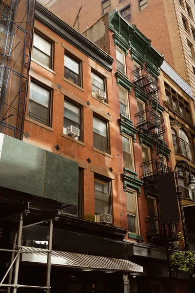 Здание из красного кирпича с пожарной лестницей в центре Нью-Йорка, городская архитектура — стоковое фото