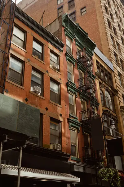 Arquitetura vintage da cidade de Nova Iorque, casa de tijolo vermelho com escadas de escada de incêndio no centro da cidade — Fotografia de Stock