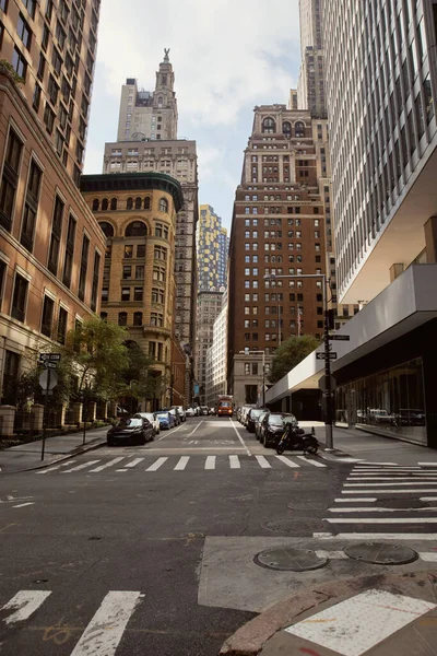 Voitures garées sur une large route près de boucles modernes et vintage dans la ville de New York, paysage urbain — Photo de stock