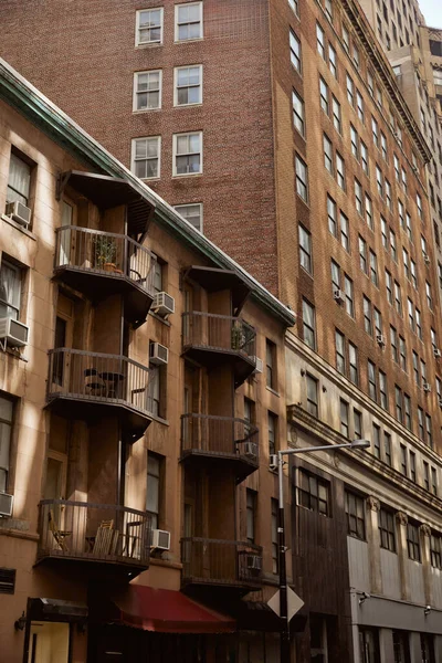Casa de época con balcones cerca de edificio moderno en la ciudad de Nueva York, arquitectura metrópolis - foto de stock