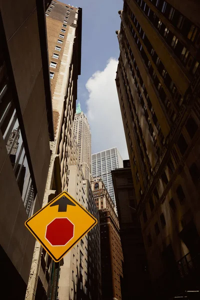 Низький кут зору дорожнього знака, високих будівель і хмарочосів в нью-йоркському місті, міському середовищі — стокове фото