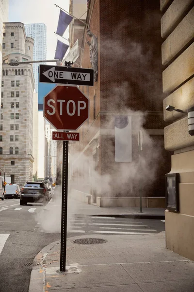 Steam near traffic signs on roadway of avenue in downtown of new york city, metropolis environment — Stock Photo