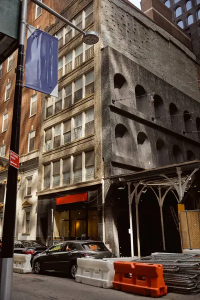 Coches aparcados cerca de edificio de ladrillo con decoración de piedra en la pared, la arquitectura creativa de la ciudad de Nueva York - foto de stock