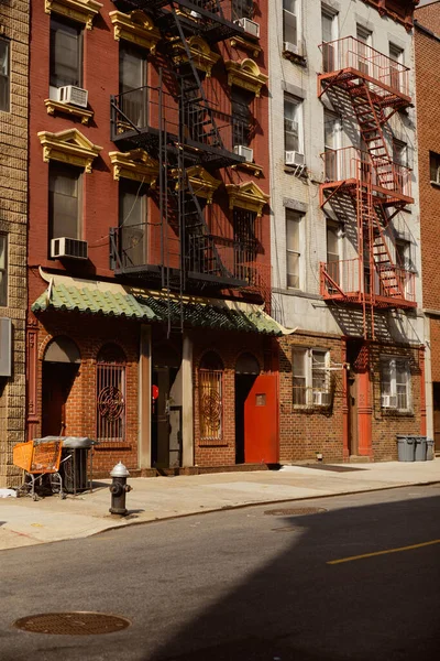 Edificios antiguos con escaleras de escape de incendios en la acogedora calle en el centro de la ciudad de Nueva York, encanto urbano - foto de stock