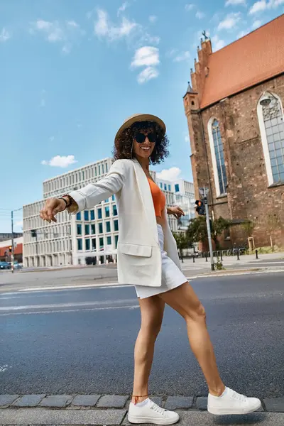 A woman in stylish attire walks down a European street. — Stock Photo