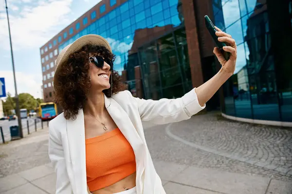 Eine modische Frau macht ein Selfie in einer europäischen Stadt. — Stockfoto