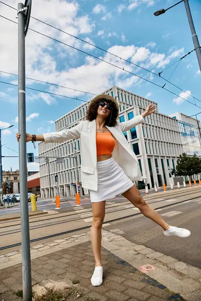 Une femme élégante profite d'une journée ensoleillée dans une ville européenne, son sourire lumineux reflétant la joie du voyage. — Photo de stock