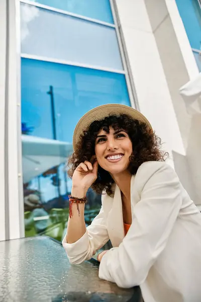 Una mujer con un atuendo elegante sonríe mientras disfruta de un día de verano en una ciudad europea. — Stock Photo