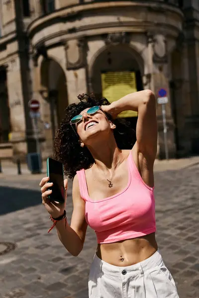 Eine Frau in stylischer Kleidung genießt einen sonnigen Tag in Europa. — Stockfoto