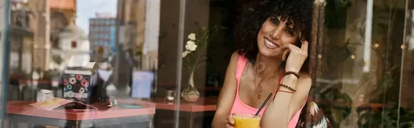 A smiling woman enjoys a beverage at a cafe in Europe. — Stock Photo