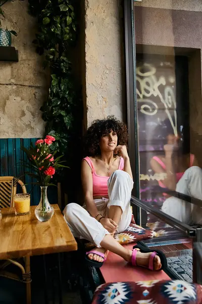 Uma mulher elegante relaxa em um café, desfrutando de um dia ensolarado de verão. — Fotografia de Stock