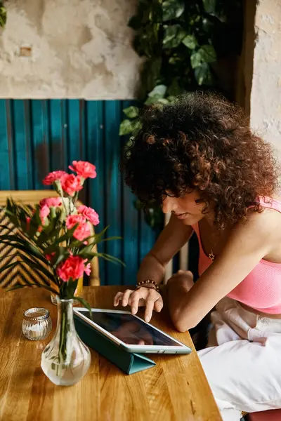 A woman in stylish attire uses her tablet while enjoying a cafe in Europe. — Stock Photo