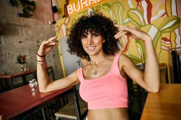 A woman in stylish attire poses at a cafe during her trip to Europe. — Stock Photo