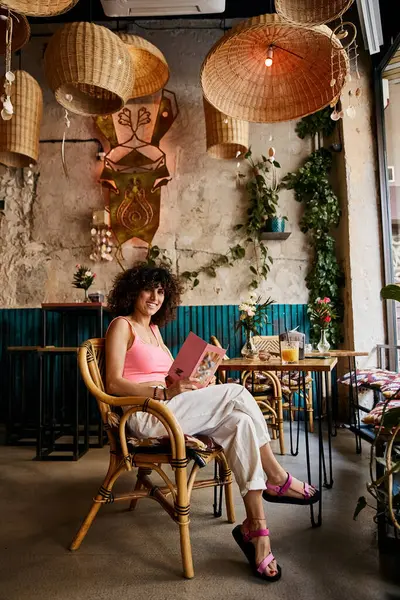 Eine Frau genießt einen gemütlichen Nachmittag in einem charmanten europäischen Café, umgeben von einzigartiger Dekoration und warmer Beleuchtung. — Stockfoto