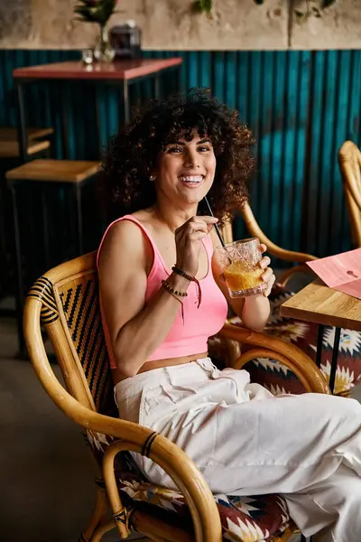 Una donna elegante si gode un drink in un caffè in Europa, sorridendo brillantemente. — Stock Photo