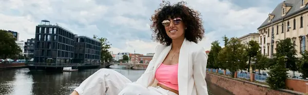Eine stilvolle Frau entspannt sich am europäischen Kanal und genießt das sonnige Wetter. — Stockfoto