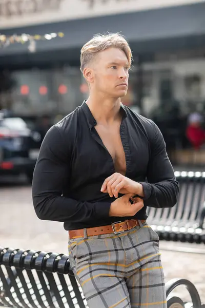 Ein hübscher blonder Mann in stylischer Kleidung steht auf einer Straße in Orlando, Florida. — Stockfoto