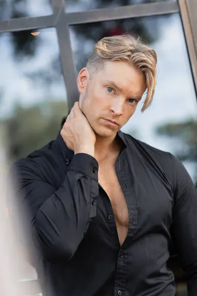 Ein hübscher blonder Mann in stylischer Kleidung steht auf einer Straße in Orlando, Florida. — Stockfoto