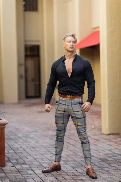 A handsome blonde man in stylish attire walks along a street in Orlando, Florida. — Stock Photo