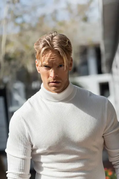 A handsome blonde man in a white turtleneck — Stock Photo