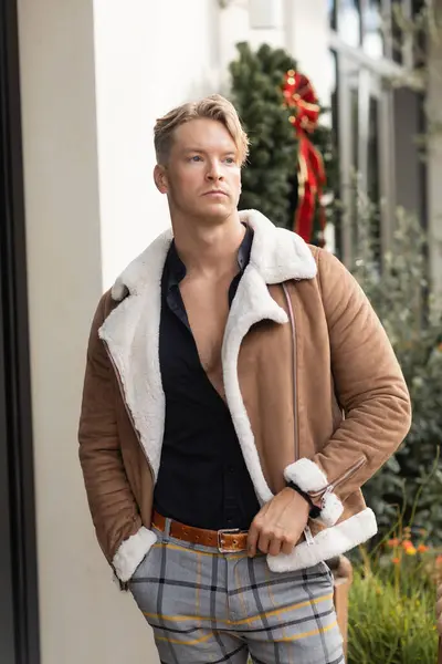 A handsome blonde man in stylish attire walks down a city street in Orlando, Florida. — Stock Photo