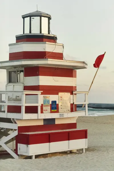 A classic Miami Beach lifeguard stand with a red flag flying, signaling caution for swimmers. — Stock Photo
