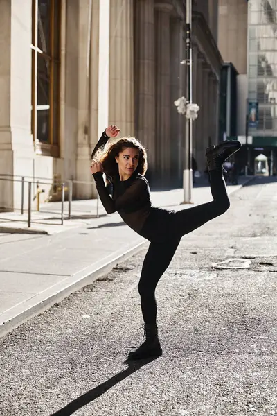 A young woman dances on the streets of New York City, showcasing her flexibility and grace. — Stock Photo
