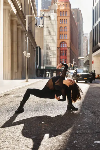 Eine junge Frau in Schwarz tanzt auf der Straße in New York City. — Stockfoto