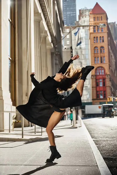 A young woman dances in the streets of New York City, her movement capturing the energy of the city. — Stock Photo