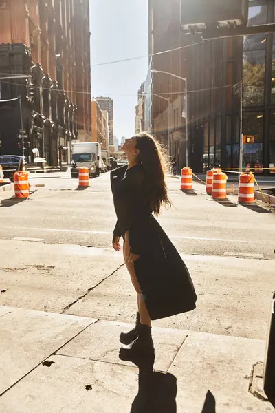 Eine junge Frau tanzt in den Straßen von New York City, in warmes Sonnenlicht getaucht. — Stockfoto