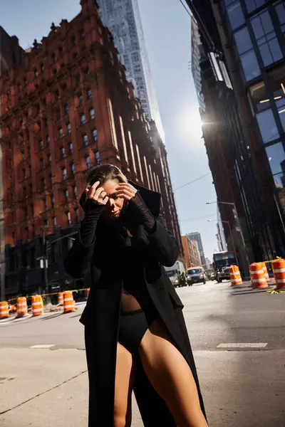 A young woman dances freely on a New York City street, bathed in the golden light of a sunny day. — Stock Photo