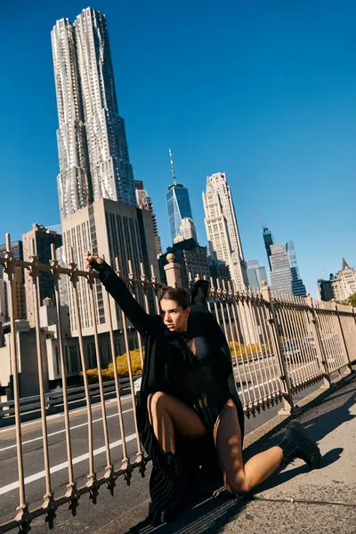A young woman in a black outfit dances on a city street in New York. — Stock Photo