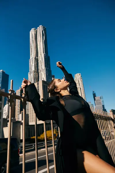 Una joven baila en las calles de Nueva York, con rascacielos al fondo. - foto de stock
