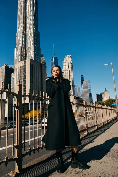 Woman in black coat dancing on NYC street, eyes on tall buildings. — Stock Photo