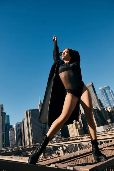 Uma jovem dança na Ponte do Brooklyn, com o horizonte da cidade ao fundo. — Fotografia de Stock