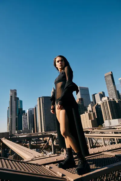 Una joven baila en un puente en la ciudad de Nueva York. - foto de stock