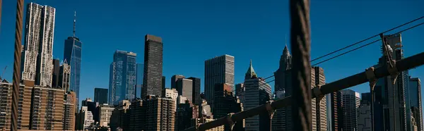 Une vue sur la skyline de Manhattan, capturée à travers les câbles d'un pont. — Photo de stock