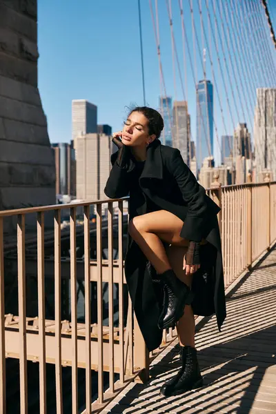 A young woman dances on a bridge overlooking the city, her movements graceful and free. — Stock Photo
