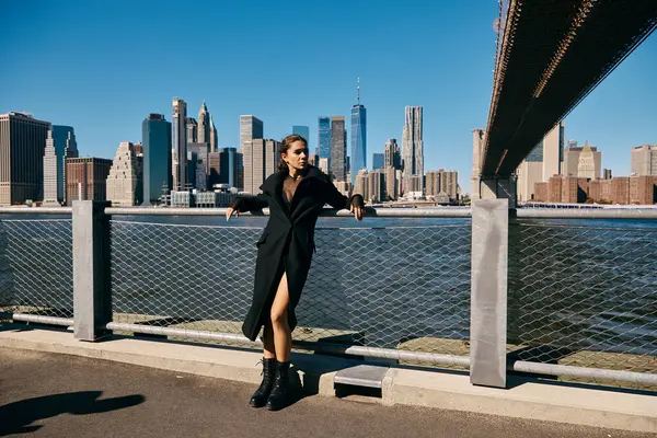 A young woman dances on a bridge in New York City, the cityscape in the background. — Stock Photo